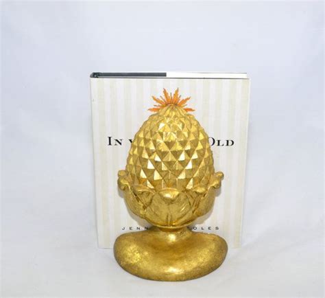A Golden Pineapple Shaped Object Sitting In Front Of A White Box With