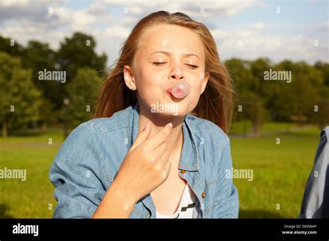 Teenage Girl In Park Blowing Bubble Gum Stock Photo Alamy