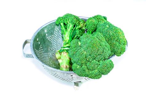 Cleaning Broccoli In The Strainer On White Background Stock Photo