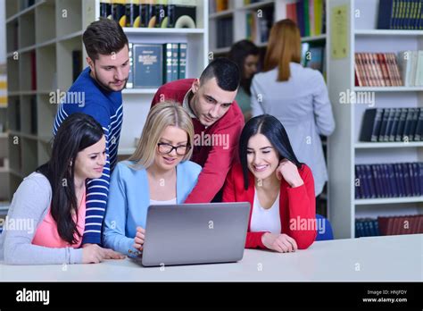 Group Of Students Working Together In Library With Teacher Stock Photo