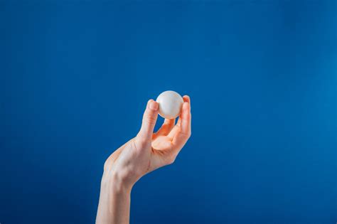 Browse Free Hd Images Of Hand Holding Ping Pong Ball On Blue Background