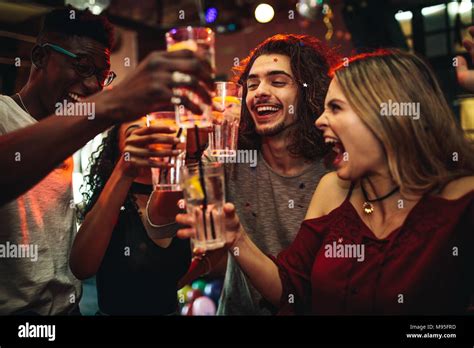 Los Jóvenes Hombres Y Mujeres Celebrando Una Fiesta Bebiendo Y