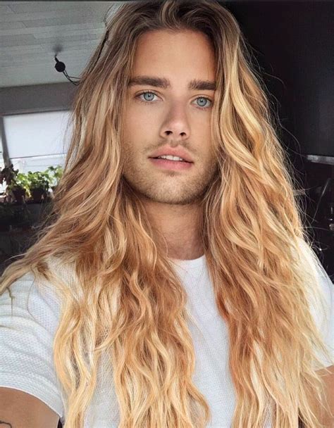 A Man With Long Blonde Hair And Blue Eyes