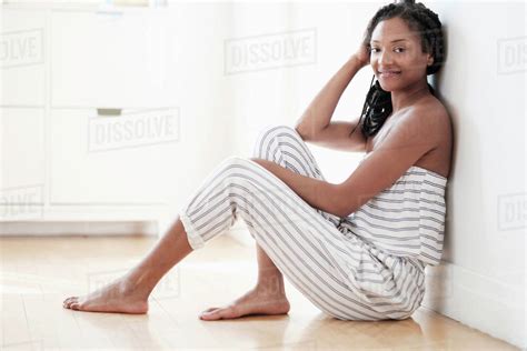 Smiling Black Woman Sitting On Floor Stock Photo Dissolve