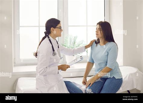 Doctor Reassuring And Supporting Young Woman While Talking To Her About