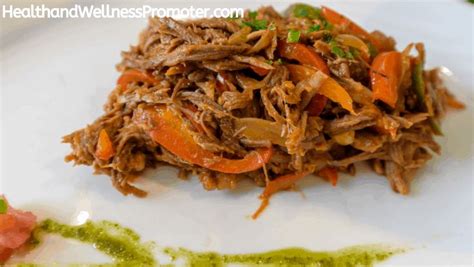 A White Plate Topped With Shredded Meat And Veggies On Top Of Its Side