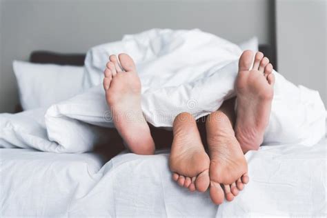 Young Man And Woman Having Fun Under Quilt In Bedroom