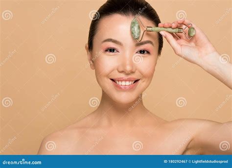 Belle Nue Asiatique Femme Faire Massage Visage Avec Rouleau De Jade