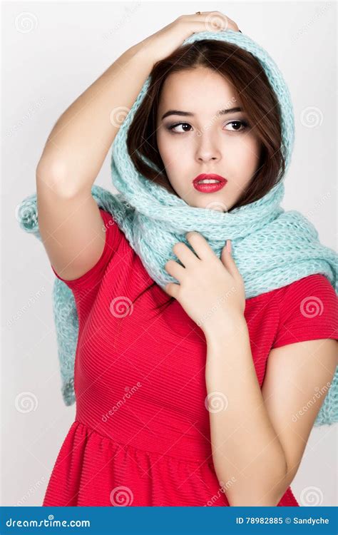 Beautiful Young Woman Dressed In A Red Dress And Scarf Posing In Studio