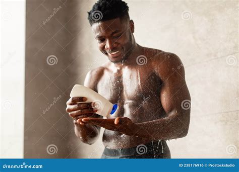 African American Man Pouring Shampoo On Hand Taking Shower Indoors