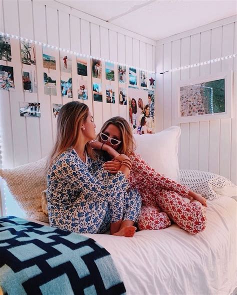 Two Women In Matching Pajamas Sitting On A Bed Looking At Each Others Eyes