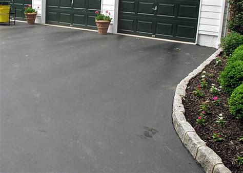 Tree trunks with the limbs removed are an excellent cheap driveway lining material. Asphalt Driveway Edging With Cobblestone Pavers
