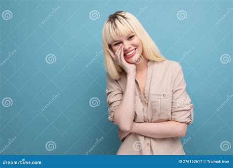 Dreamy Blond Woman In Shirt Smiling Shyly On Blue Background With Copyspace Stock Image Image