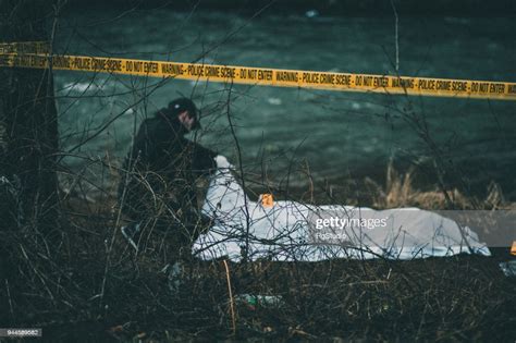 Detective Investigating Crime Scene By The River High Res Stock Photo