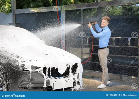 Businessman Cleaning Auto With High Pressure Water Jet Stock Photo