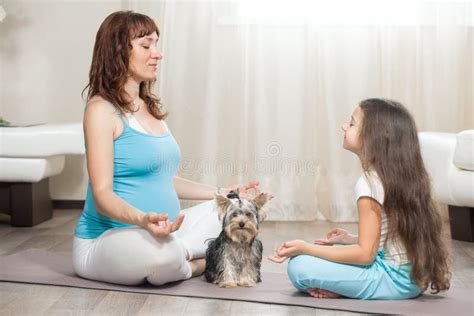 Madre Embarazada Que Medita En Casa Con Su Hija Y Perro Casero Imagen