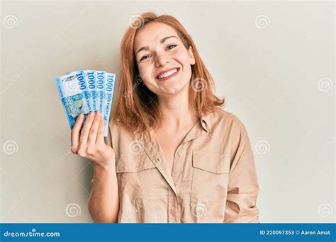 Young Caucasian Woman Holding Hungarian Forint Banknotes Looking Positive And Happy Standing And