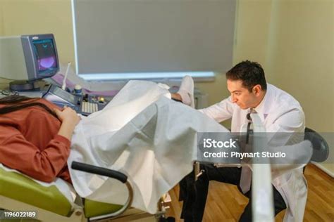 Woman In Gynecological Chair During Gynecological Check Up With Her Doctor Gynecologist Examines