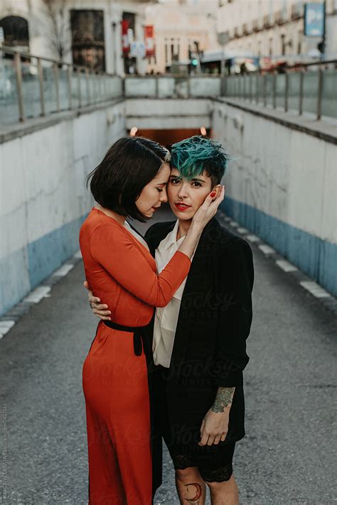 Young Stylish Ladies Embracing On Street By Addictive Creatives Lesbian Couple