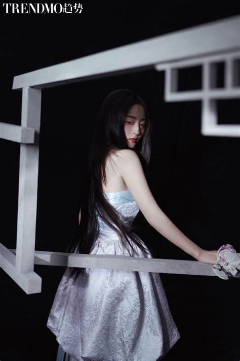 A Woman In A Silver Dress Holding Onto A White Fence With Her Hand On The Railing