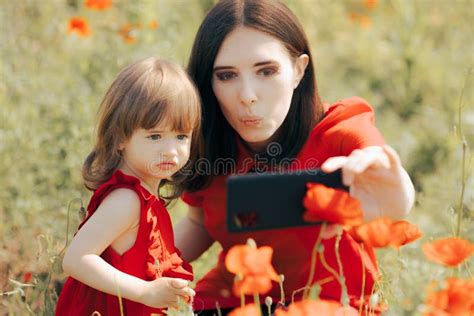 Mother And Daughter Taking Selfies In A Poppy Field Stock Image Image