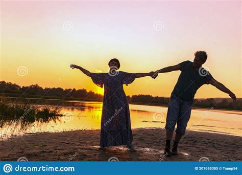 Mature Couples Dance On A Wild Beach In The Rays Of The Setting Sun On