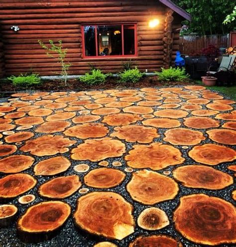 An Outdoor Area With Wood Slices On The Ground In Front Of A Log Cabin