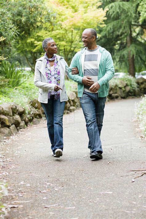 Smiling African American Couple Walking In Park Stock Photo Dissolve