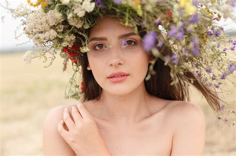 Premium Photo Beautiful Woman With A Wreath On Her Head Sitting In A Field In Flowers The