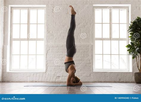 Young Woman Practicing Yoga Standing In Headstand Pose Salamba