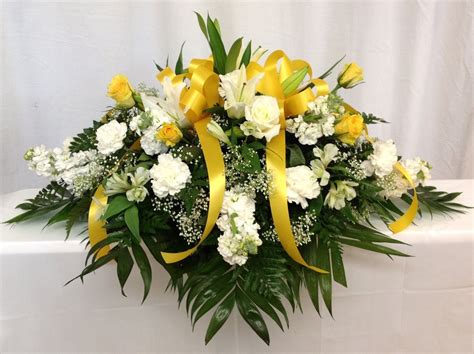Beautiful white casket in a vintage style of standing on a white cloth with a sprig of a tree on the cover. Yellow & White Casket Spray | Casket sprays, Funeral ...