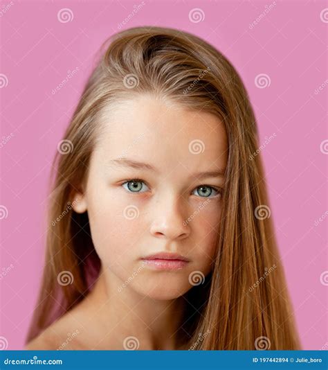 Portrait Of A Gentle 9 Year Old Long Haired Girl Against A Lilac Wall