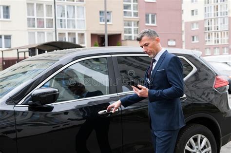 Handsome Male Businessman In A Suit Stands Next To A Black Car Concept