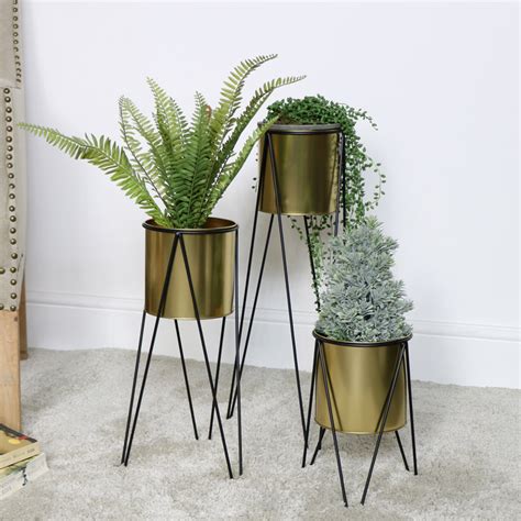 A plant stand is a great way to draw attention to your plant, while also lifting it off the ground. Set of 3 Gold Plant Stands