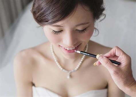 A Woman In A Wedding Dress Is Holding A Pen