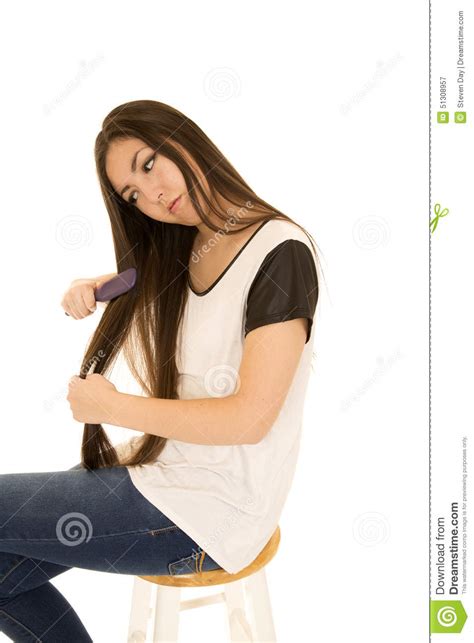 Asian American Teen Girl Sitting And Brushing Her Hair Stock Image