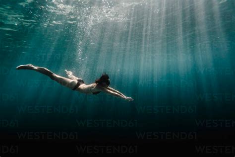 Full Length Of Woman Swimming Underwater In The Ocean Cavf