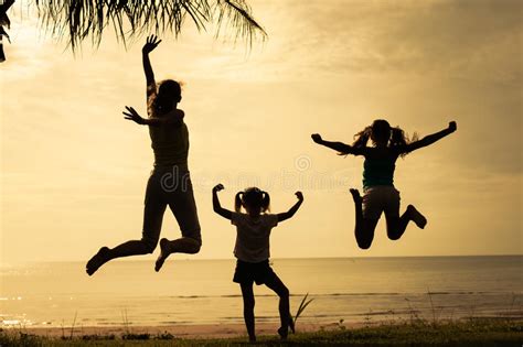 Madre E Hijas Que Saltan En La Playa Foto De Archivo Imagen De