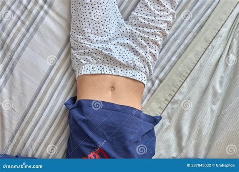 Girl Lying On A Bed With Her Belly Button Exposed Stock Photo Image