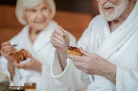 Ein älteres glückliches paar das das frühstück genießt während es im bett bleibt Premium Foto