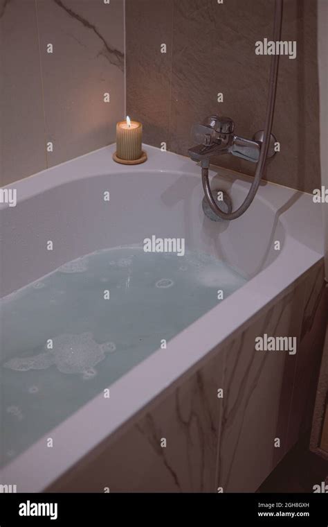 Beautiful Shot Of A Bathtub Filled With Bubbly Water And Aroma Candles