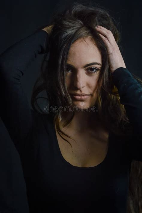 portrait of a beautiful long haired italian woman who with her hands on her head has an