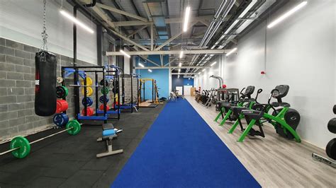The gym features cardio and weight machines on transparent floors and tvs all around. National Indoor Arena Private Gym | Sport Ireland Campus