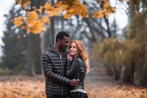 Casal Interracial Feliz Colocando Se Em Segundo Plano No Outono Foto De Stock Imagem De