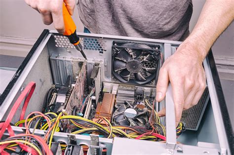 Man Fixing An Old Desktop Computer Using A Screwdriver Stock Photo