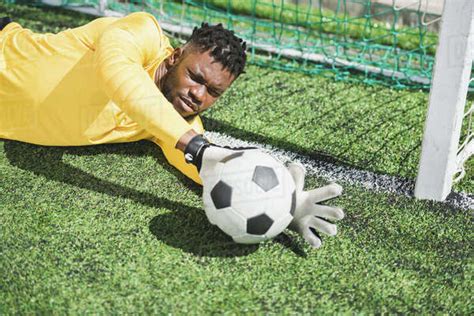 Portrait Of African American Goalkeeper Catching Ball During Soccer