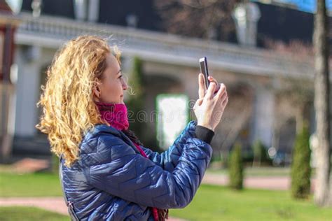 Woman In Bright Clothes Takes A Selfie On The Phone On A Sunny Day