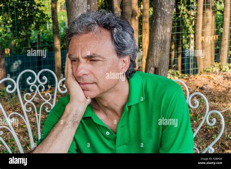 Tired Tanned Man Holding His Chin With Right Hand While Resting In A