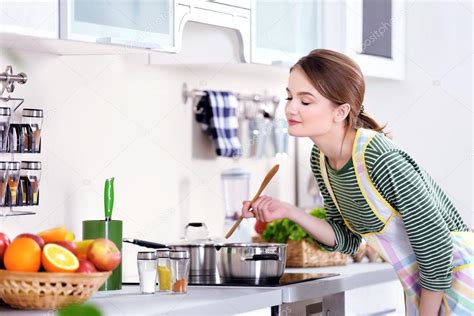 Young Woman Cooking In Kitchen Stock Photo By ©belchonock 103309700