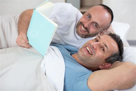 Two Mature Men In Bed Looking At A Book Photo Background And Picture For Free Download Pngtree